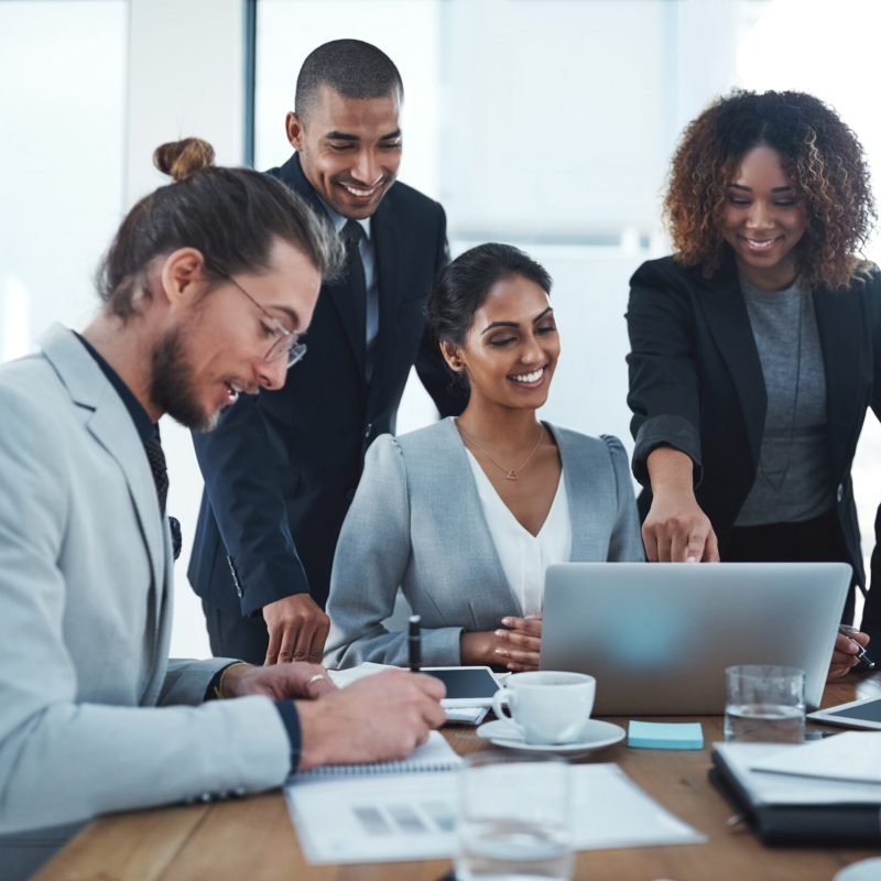 Shot of a group of businesspeople discussing something on a laptop
